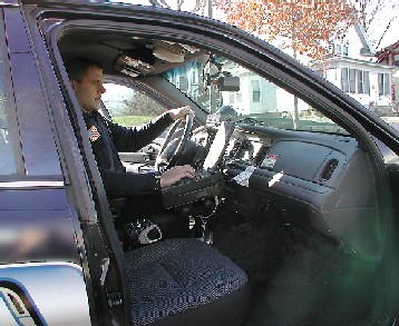 Image of police officer accessing CriMNet database while in squad car