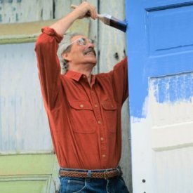 Image of man painting a door